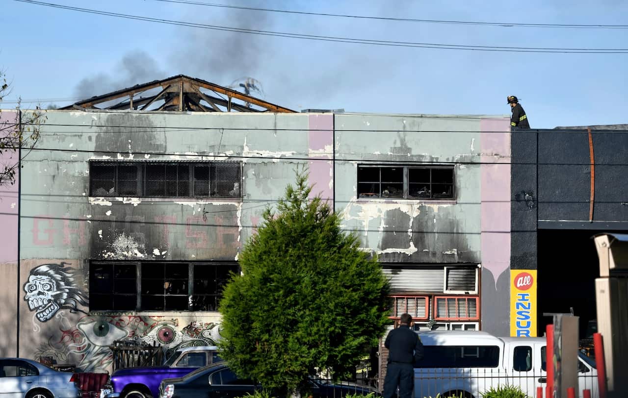 Firefighters work at the aftermath of a warehouse fire in the Fruitvale district of Oakland at the corner of 31st (AAP)