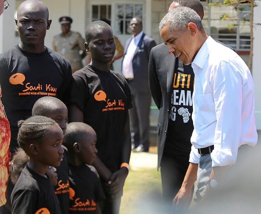 Former US President Barack Obama talks to children in his ancestral home in Kogelo.