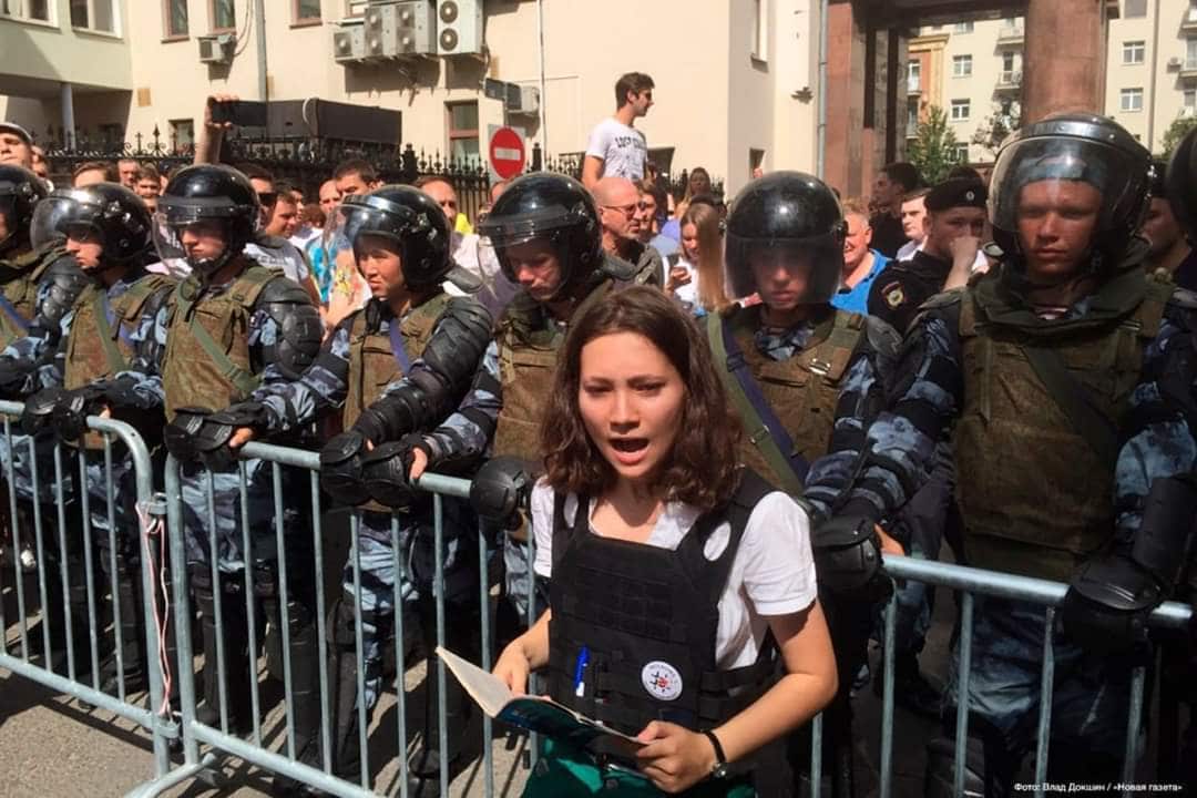 A 17 year -old Russian girl is being hailed as a hero and symbol of resistance after she was photographed reading the Russian constitution to a group of armed riot police at a bloody protest.