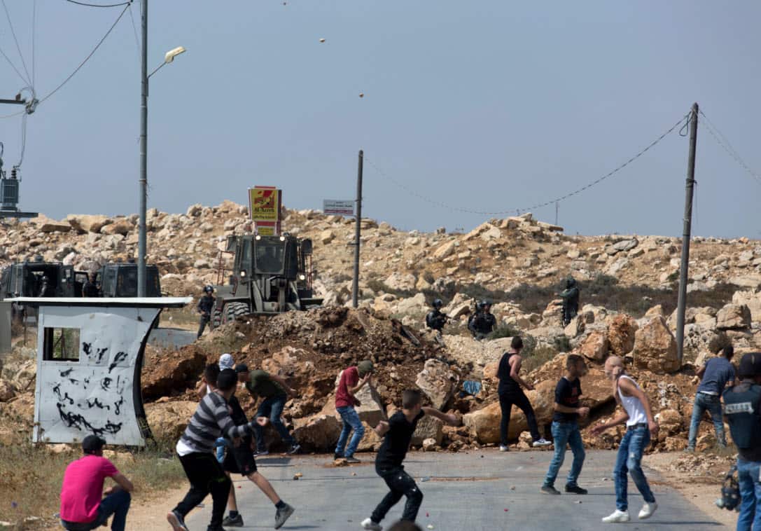 FILE; Palestinian protesters clash with Israeli soldiers during their operation to search and measure the family house of Omar al-Abed.