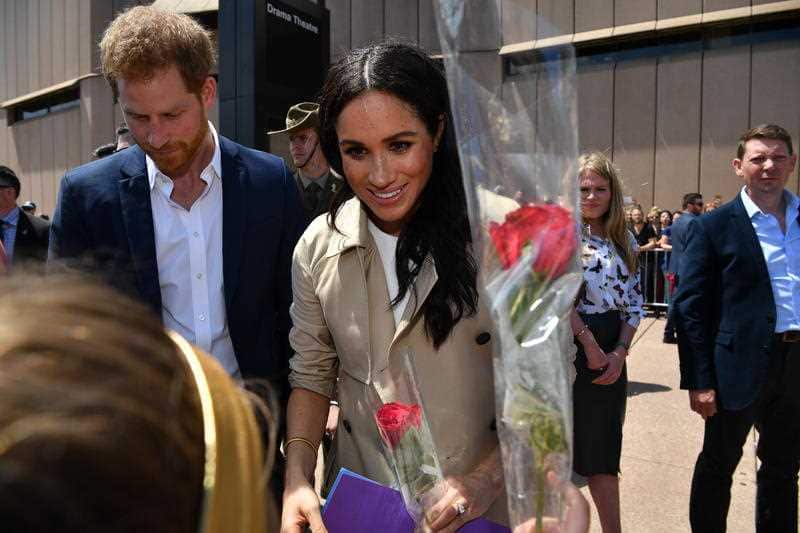 Britain's Prince Harry, the Duke of Sussex, and his wife Meghan, the Duchess of Sussex, are seen during a meet the people walk at the Sydney Opera House.