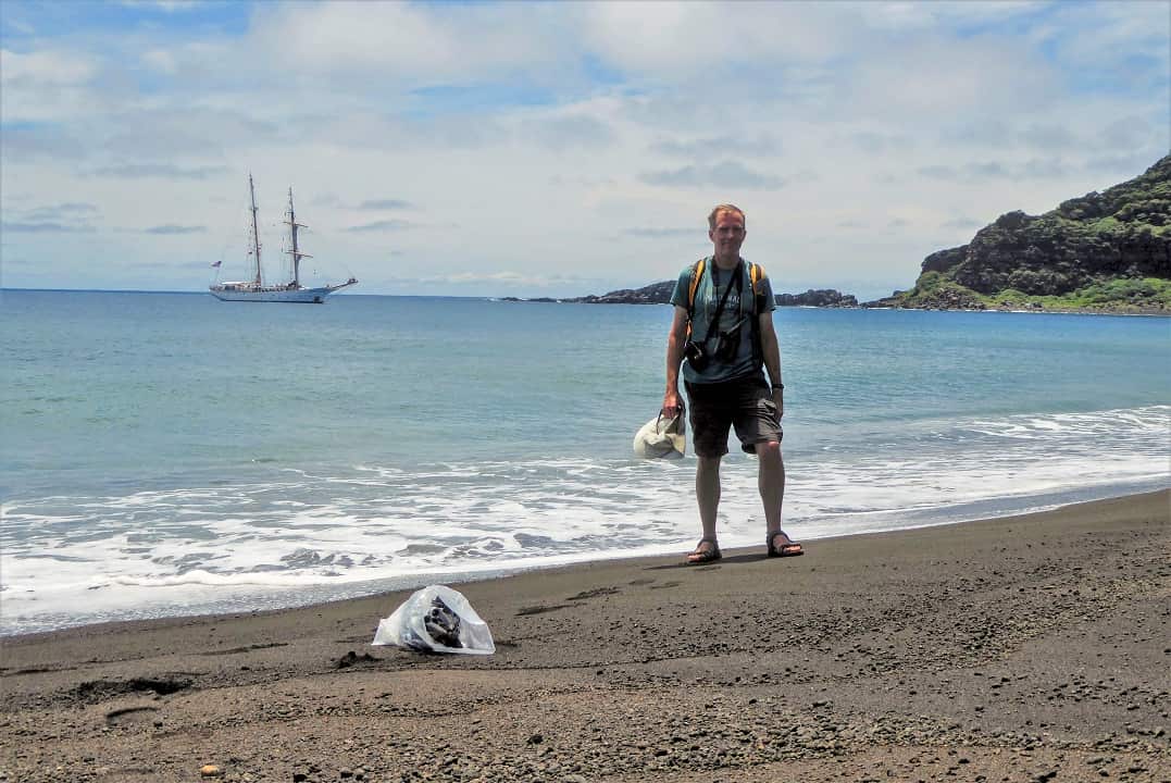 NASA research Dan Slayback standing on the beach of the volcanic island.