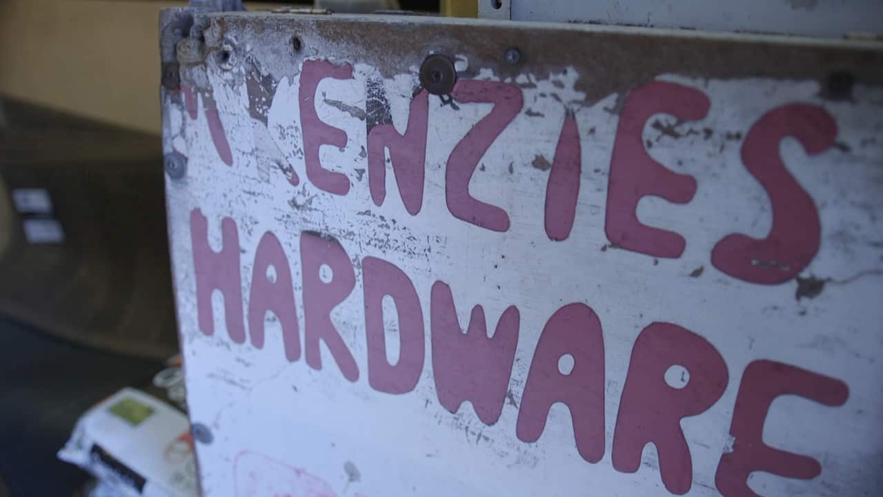 Paint peeling off exterior of the hardware store.