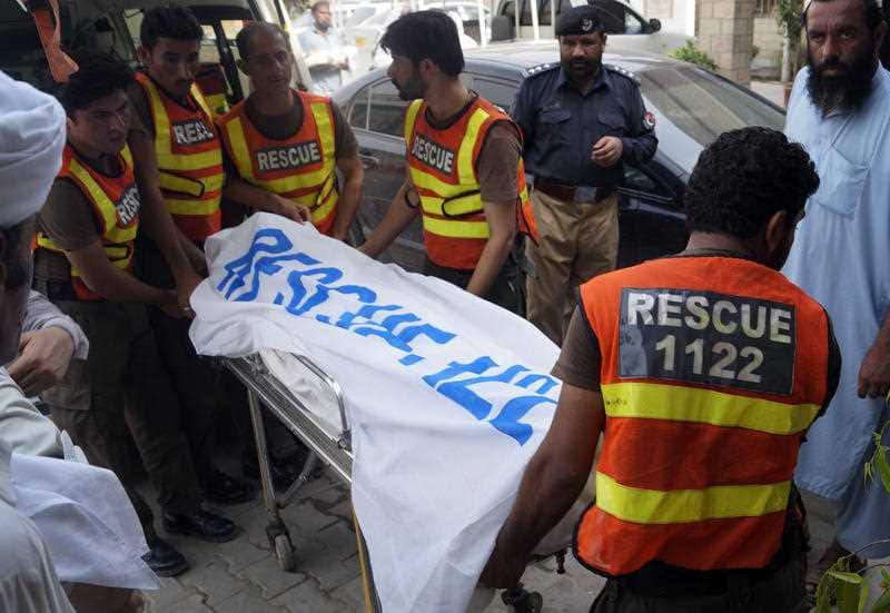 Rescue workers move the body of Ikramullah Gandapur, a candidate from opposition leader Imran Khan's party, who was killed in the suicide bombing.