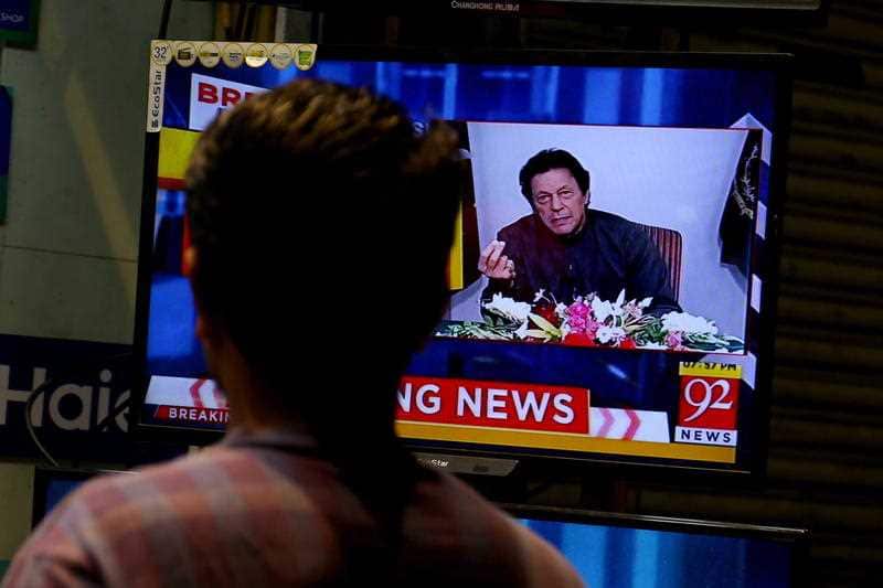 People listen to Khan's address in Pakistan. 