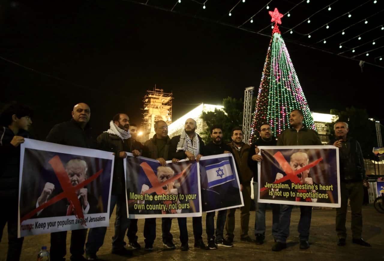 Palestinian hold posters of the U.S. President Donald Trump during a protest in Bethlehem, West Bank, Tuesday, Dec. 6, 2017 (AAP)