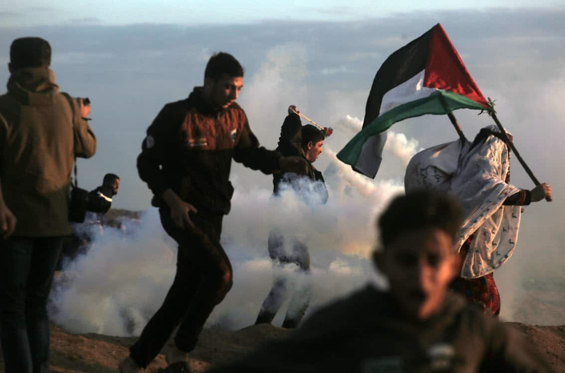 Palestinian protesters during the clashes after Friday protests near the border between Israel and Gaza Strip in the east Gaza Strip, 21 December 2018 (AAP)