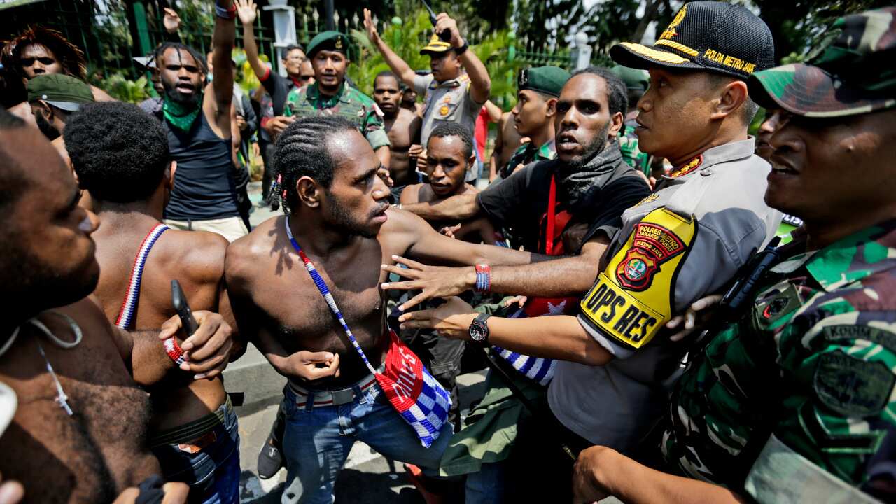 Papuan activists scuffle with police and soldiers during a rally near the presidential palace in Jakarta, 22 August 2019. 