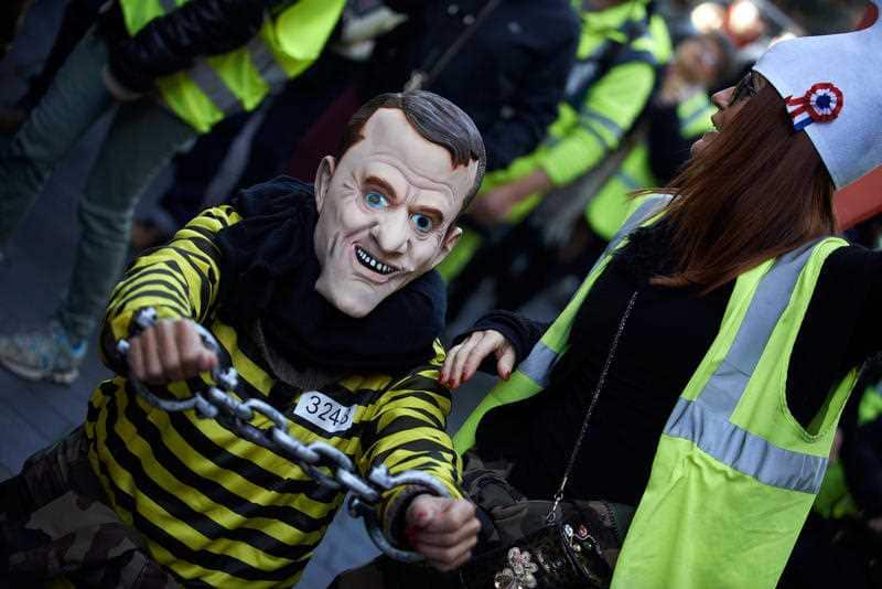 A 'Marianne' keeps a false Macron in chains amid the riots.