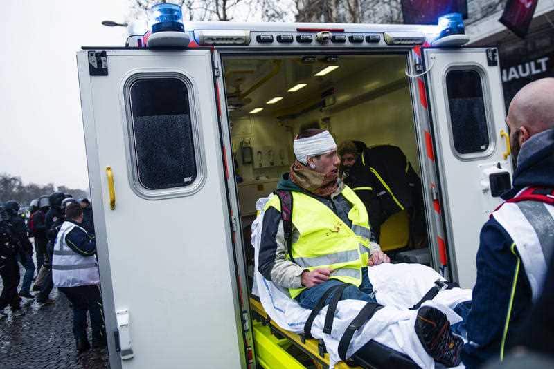 A 'Gilets Jaunes' ('Yellow Vest’) protester treated by paramedics after being injured by riot police in the Champs Elysees Avenue in Paris.