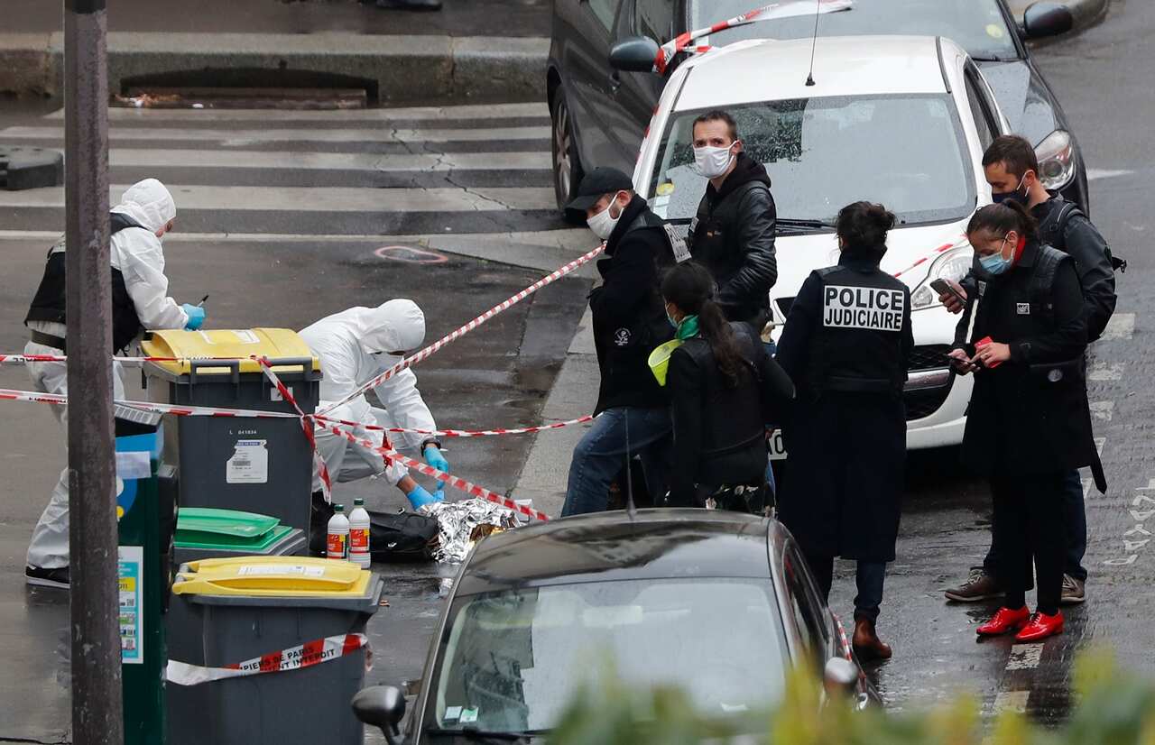 Police officers patrol the site of a knife attack near the former offices of satirical newspaper Charlie Hebdo.