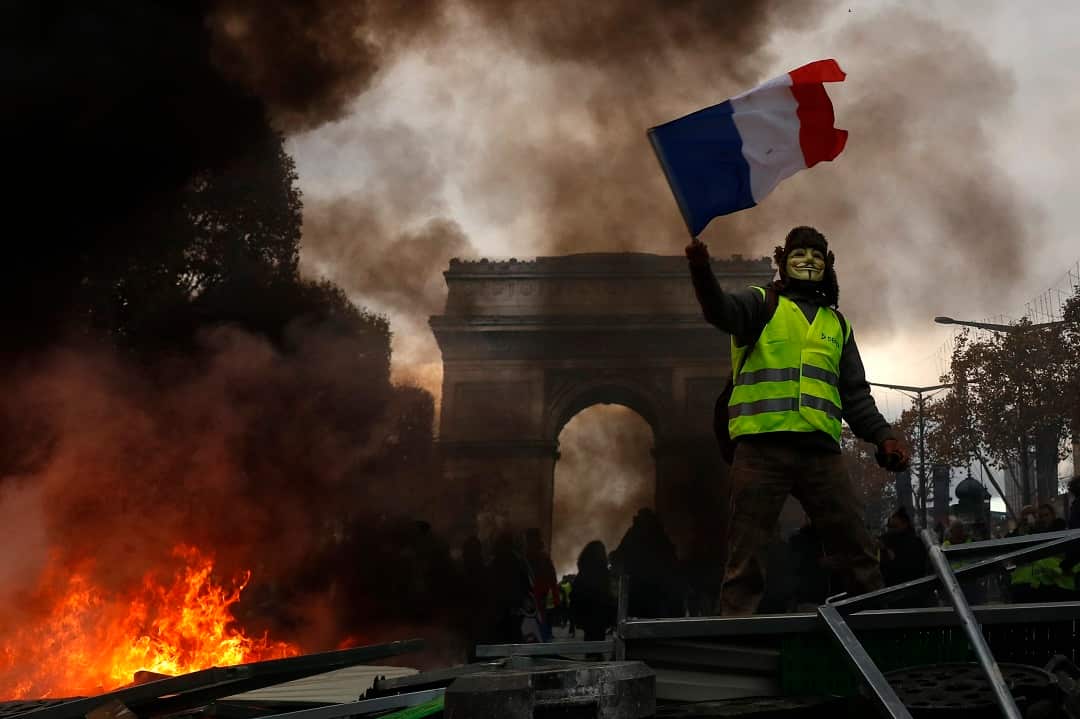Yellow vests (Gilets jaunes) protest against rising oil prices and living costs near the Arc de Triomphe on the Champs Elysees in Paris.