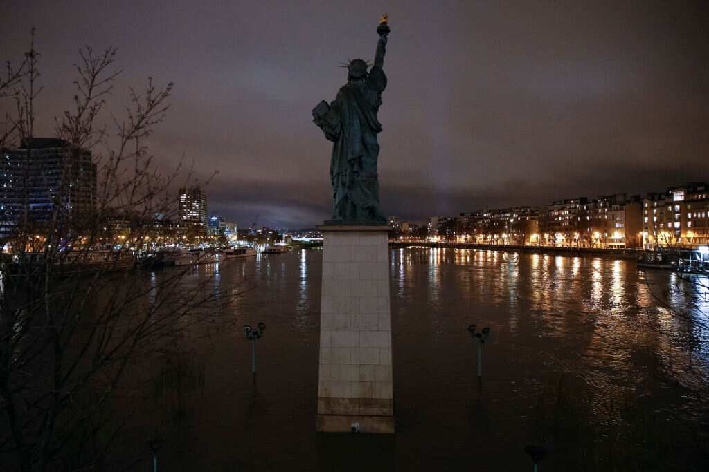 The French replica of the Statue of Liberty on the flooded Ile aux Cygnes (Swans Island) by the banks of the Seine river. 