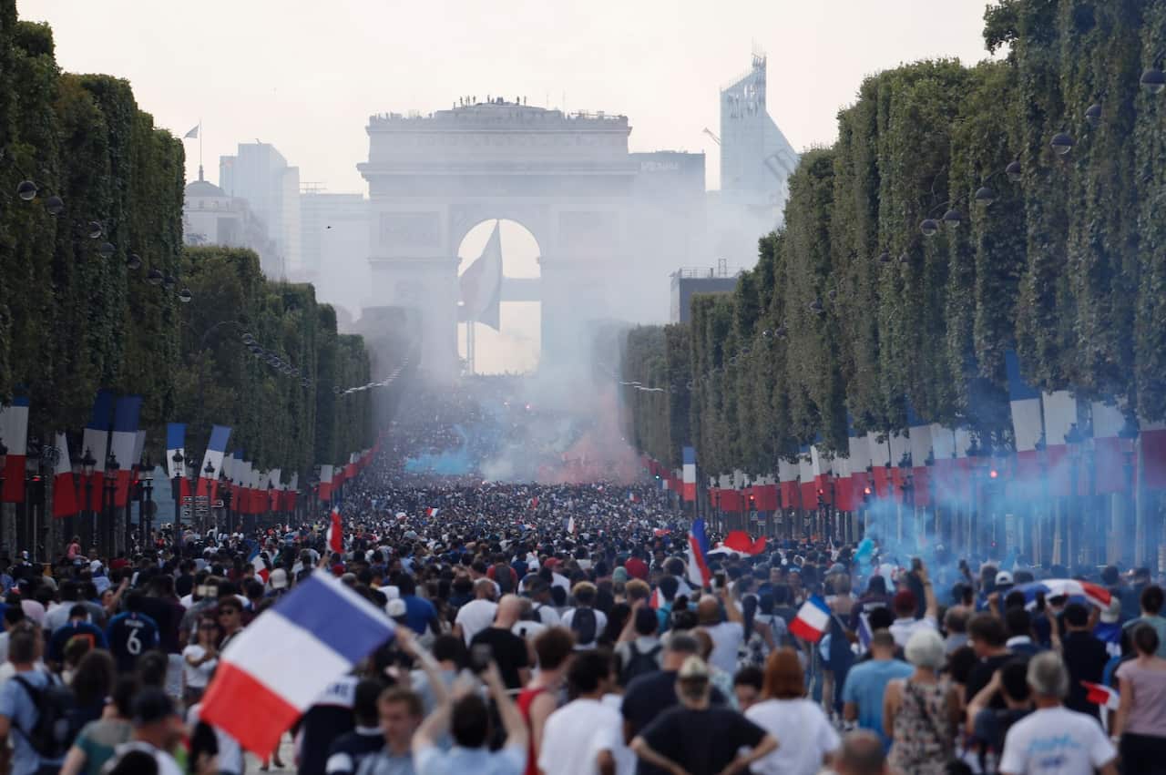 French supporters gather on the Champs-Elysees avenue after the victory of France at the FIFA World Cup 2018 final match