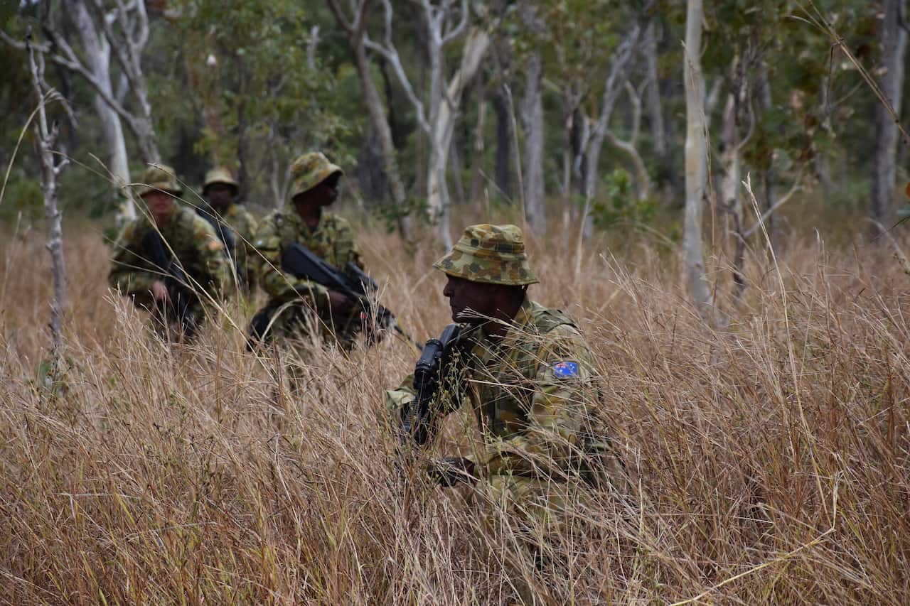 A patrol from 51 Battalion, Far North Queensland Regiment moves through the scrub. The soldiers blend traditional skills with modern technology.