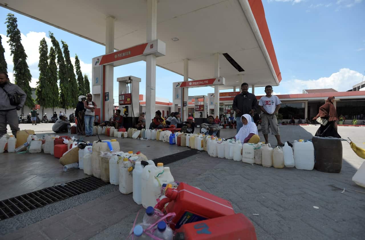A line of bottles waiting to be filled at a gas station in the city of Palu.
