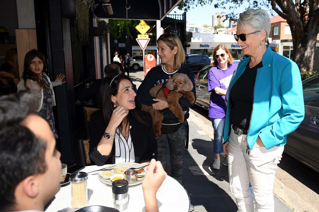 Independent candidate for Wentworth Kerryn Phelps (right) and partner Jackie Stricker (third right) speaks with constituents in Double Bay.