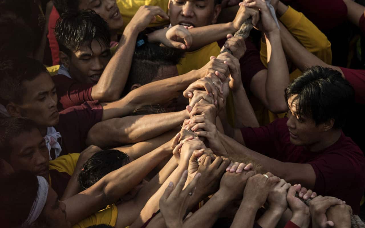 A devotees trying to touch the rope of Black Nazarene statue while entering at Chinese & Filipino Peace Arch in Binondo.