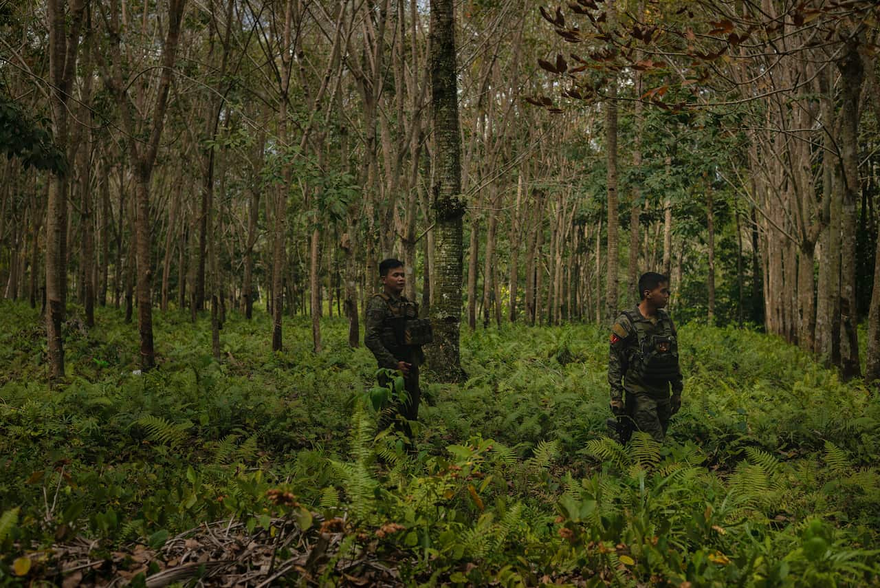 Soldiers secure a post during a ceremony held to hand out houses to former insurgents in Tipo-Tipo, in the Philippines.