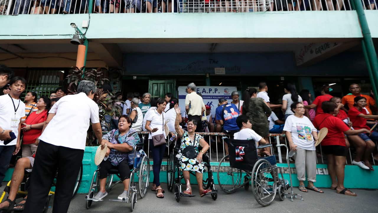 Residents wait for their turn as voting starts at a polling center at the Manuel L. Quezon elementary school, Manila.