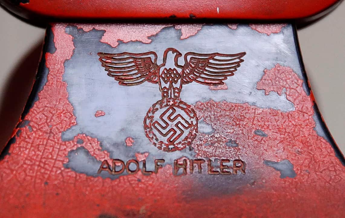 An engraving of a swastika and Adolf Hitler's name are seen on the back of Hitler's personal travelling telephone (AAP)
