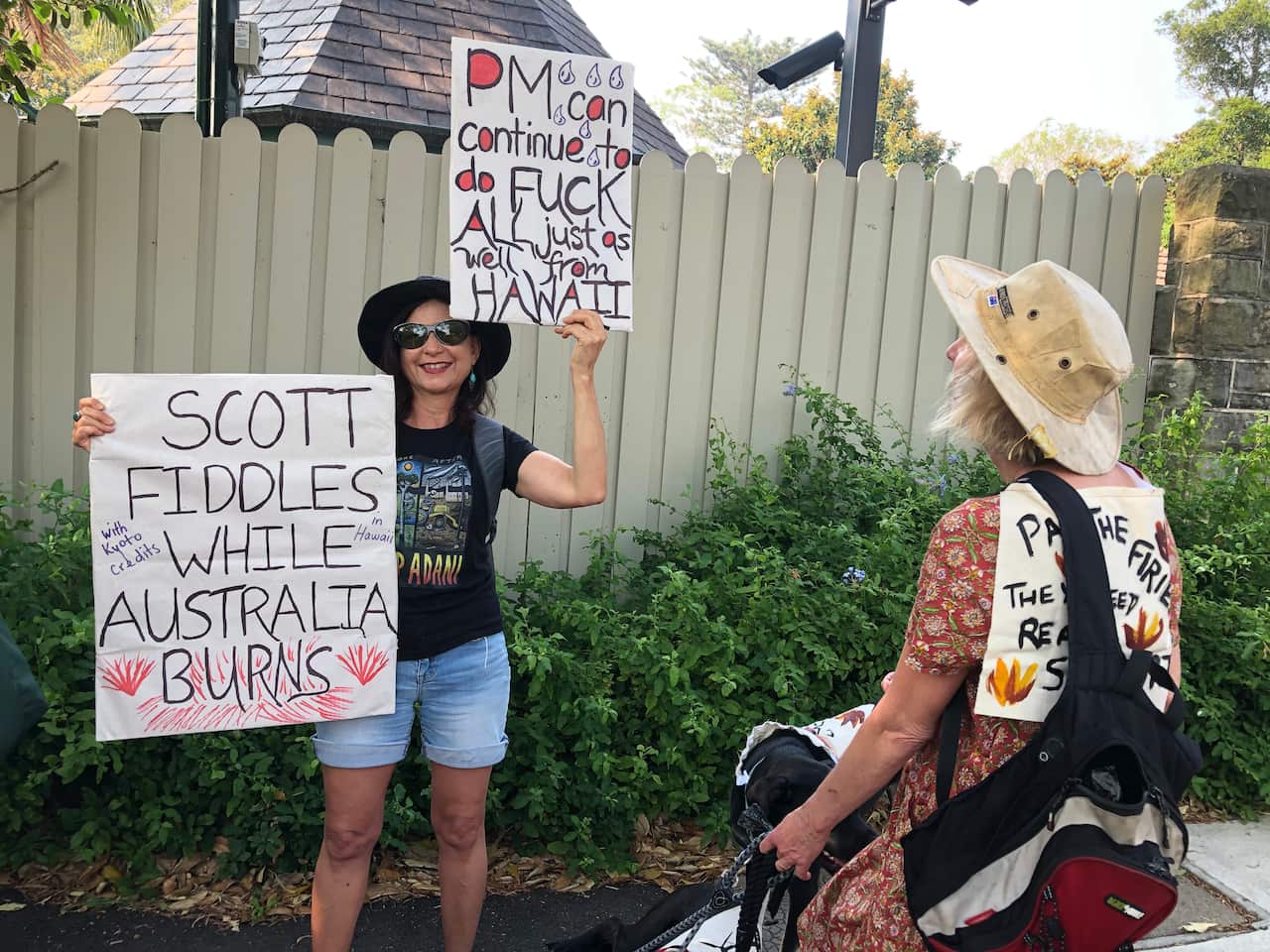 Protesters hold signs outside Kirribilli House