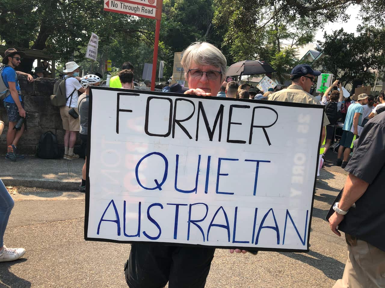 A protester holds a sign reading "former quiet Australian"