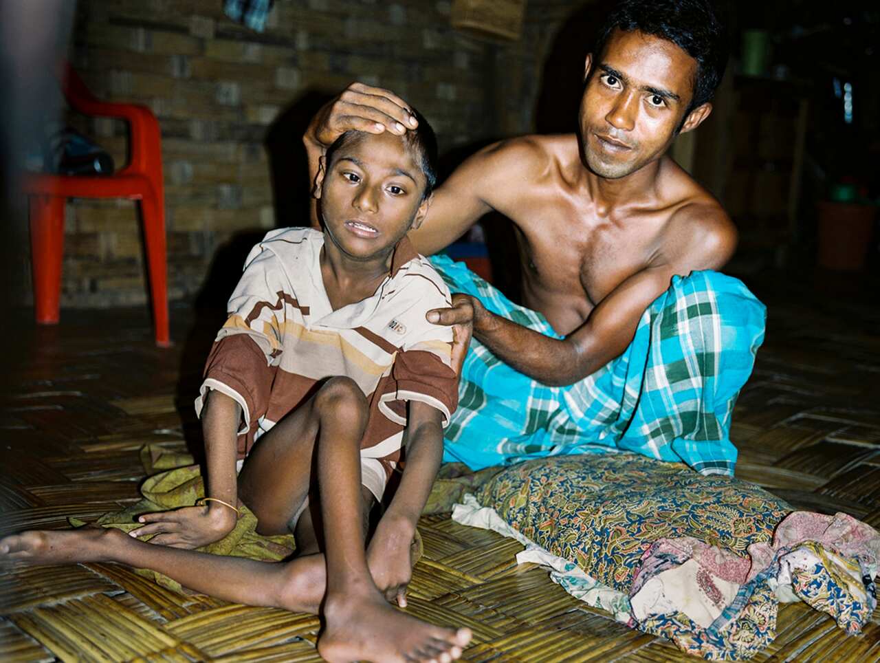 A father helping his son with polio pose for a picture with Ali MC.