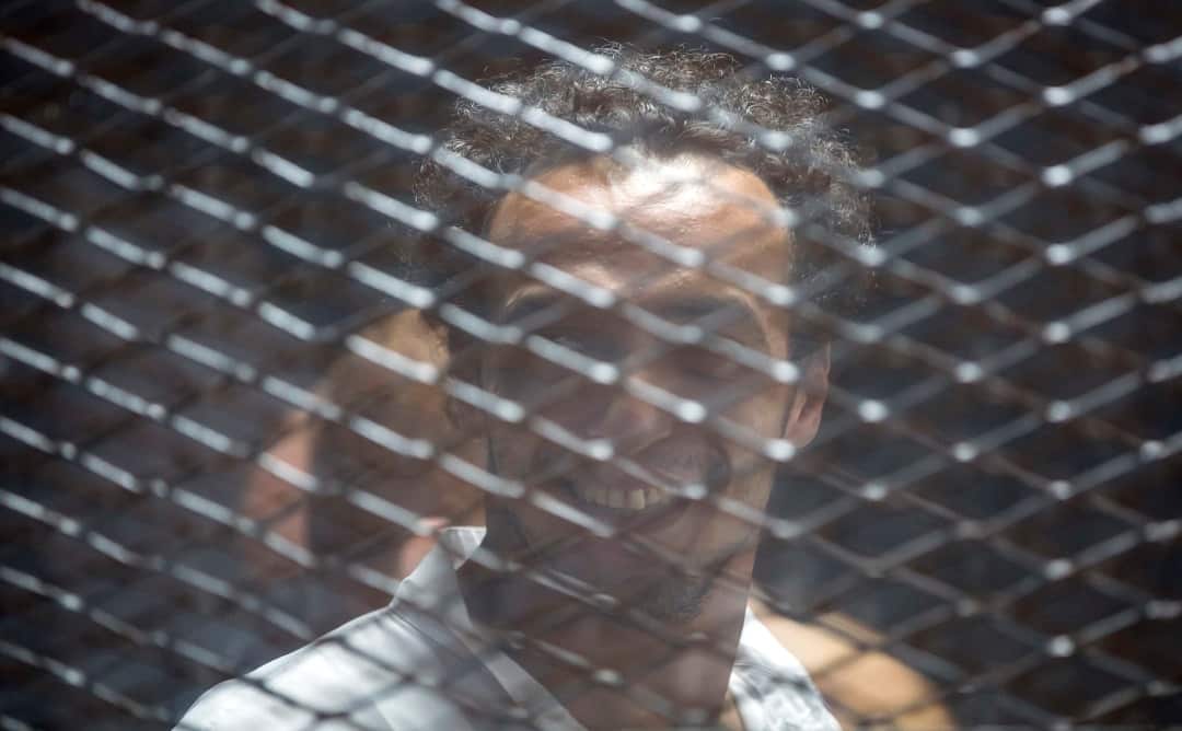 Photojournalist Shawkan Seen in the cage after hearing the verdict.
