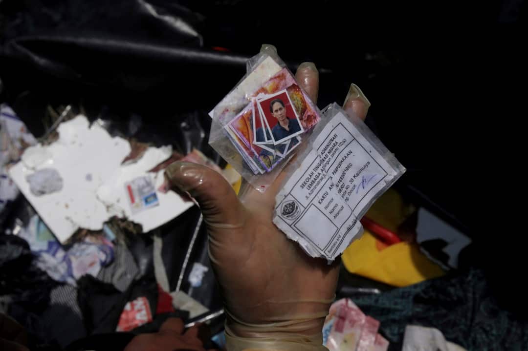 A rescuer inspects personal belongings of passengers during the search operation for the victims of the Lion Air jet. 