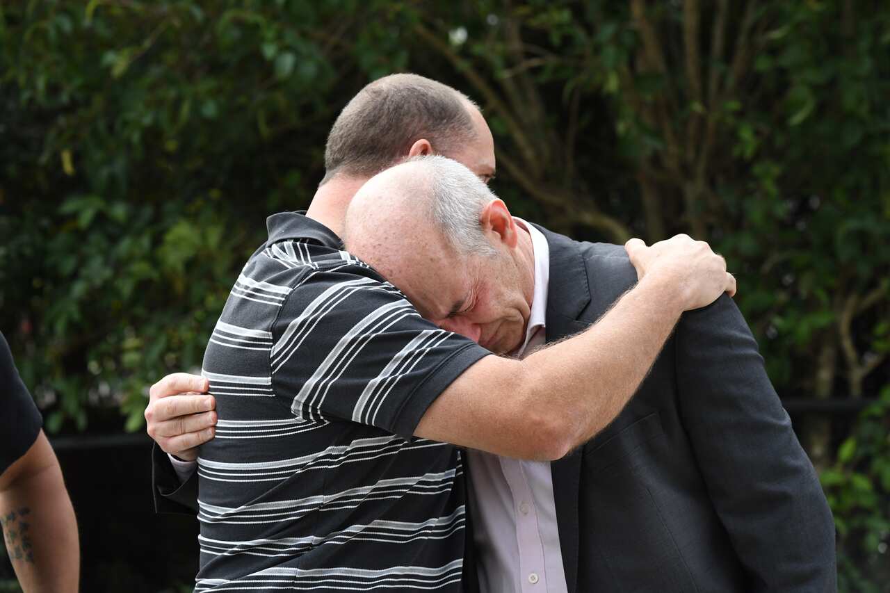 Matthew King, the father of Alex King, 19, embraces Cornelius Brosnan, the father of Callum Brosnan, 21, outside the Coroner's Court.