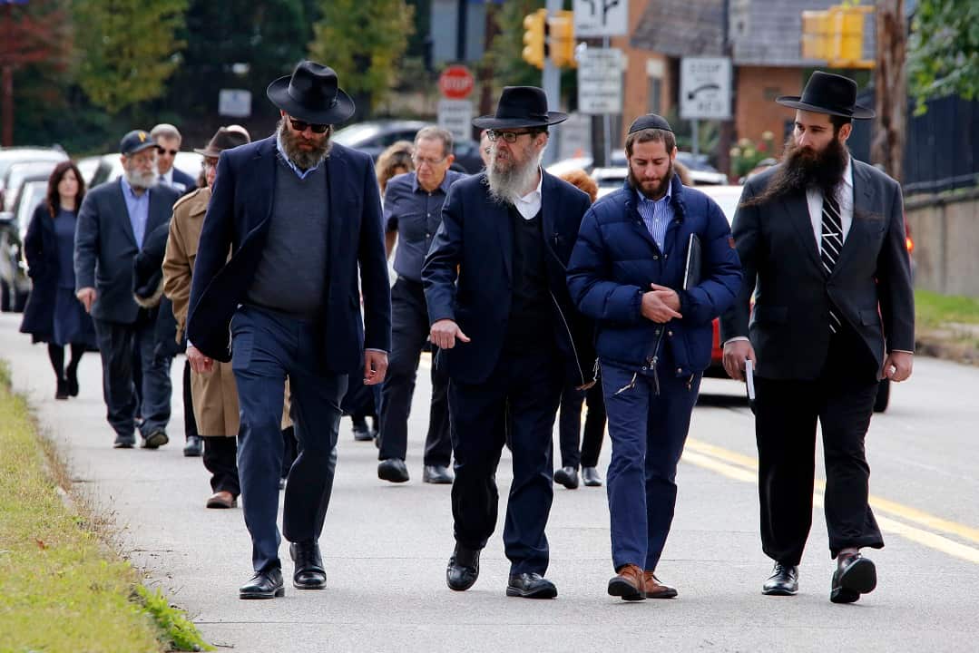 Mourners walk behind the hearse carrying the casket of Dr. Jerry Rabinowitz.