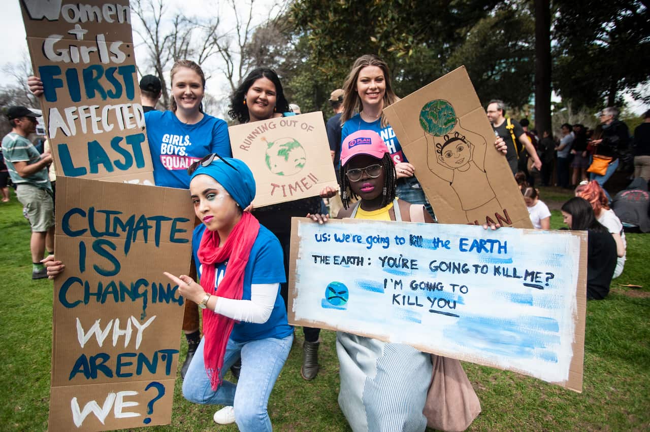 Plan International Australia ambassadors show off their climate strike signs. 