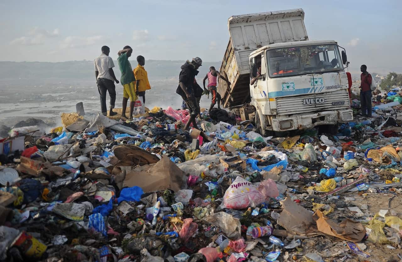A picture taken on June 2, 2018, shows people scavenging at a dumping site in Mogadishu, Somalia.