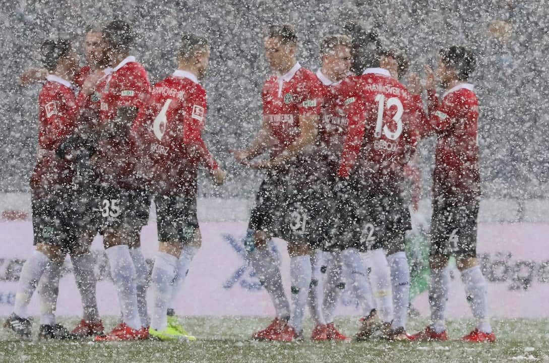 Hannover players covered in snow during the German Bundesliga soccer match between Hannover 96 and TSG Hoffenheim.