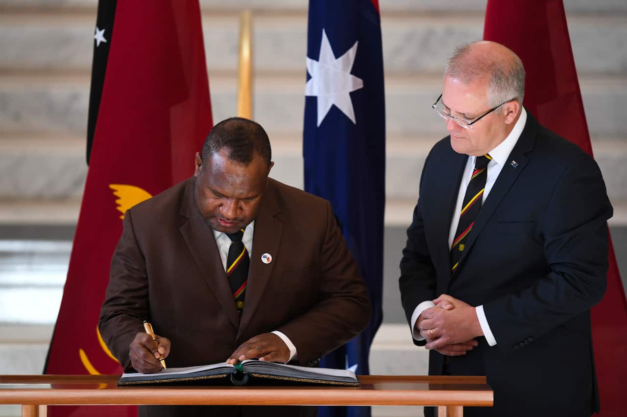 Mr Marape signs the visitors book at Parliament House in Canberra.