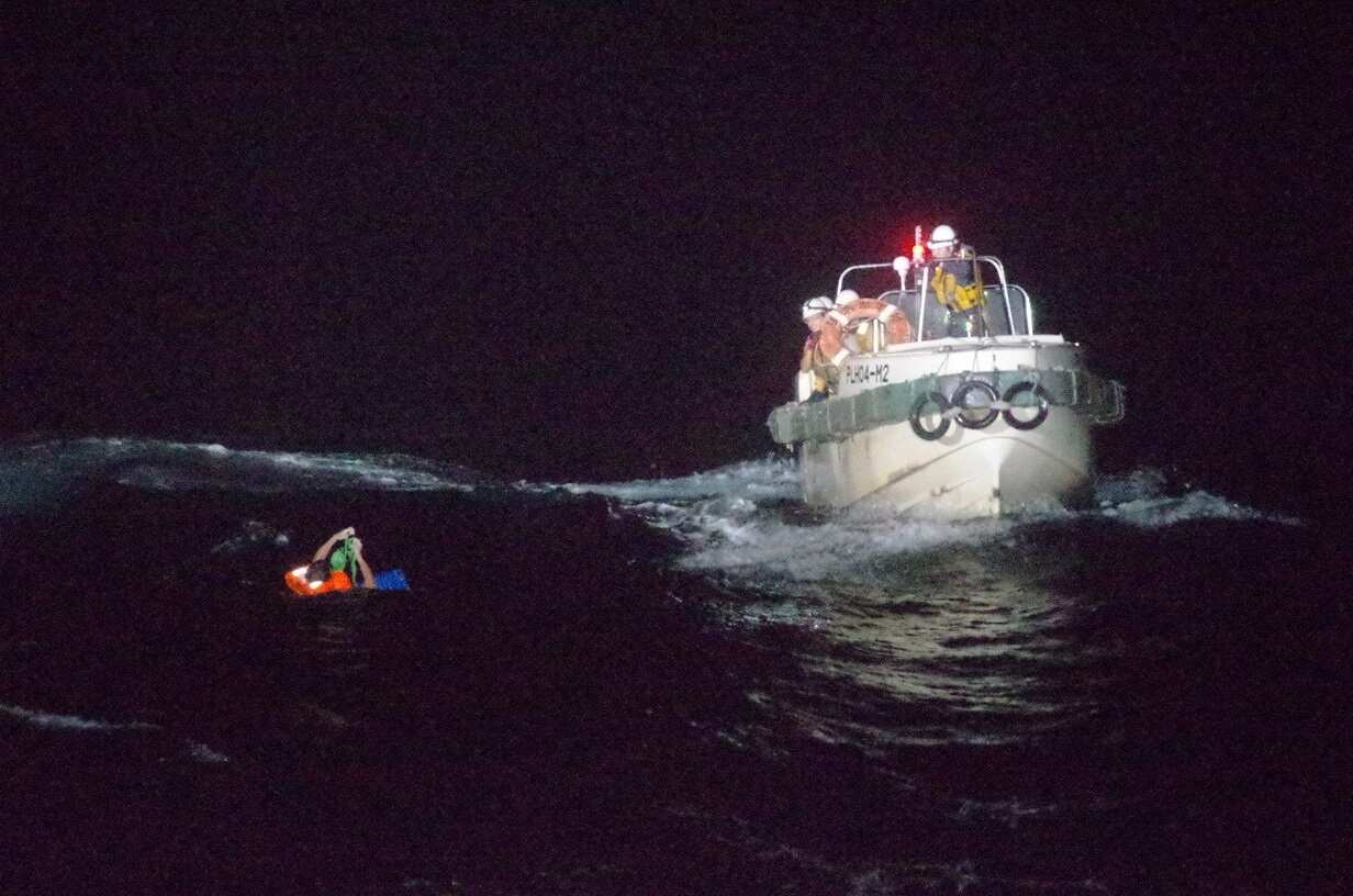 Japan Coast Guard officers rescue a crew member of the capsized ship. 