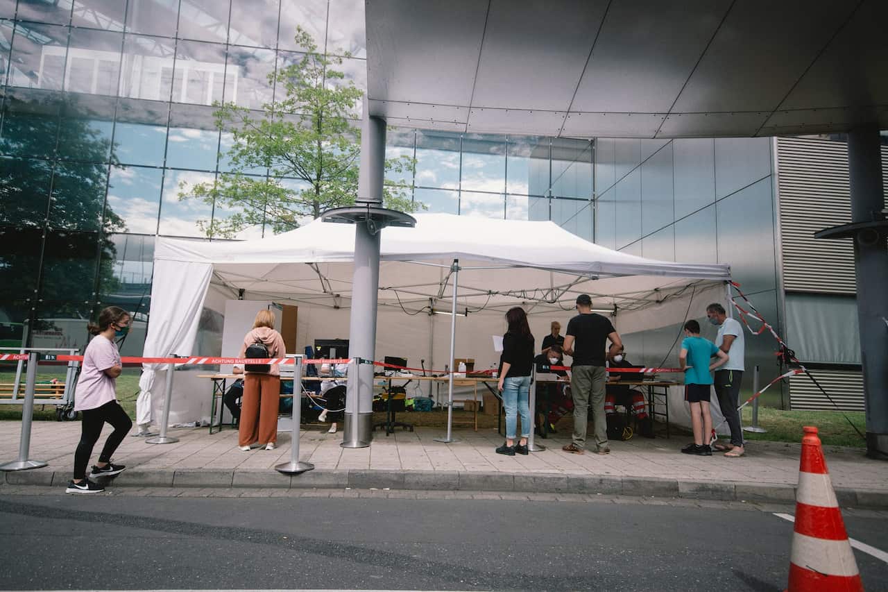 People queue up for coronavirus testing in Cologne, Germany