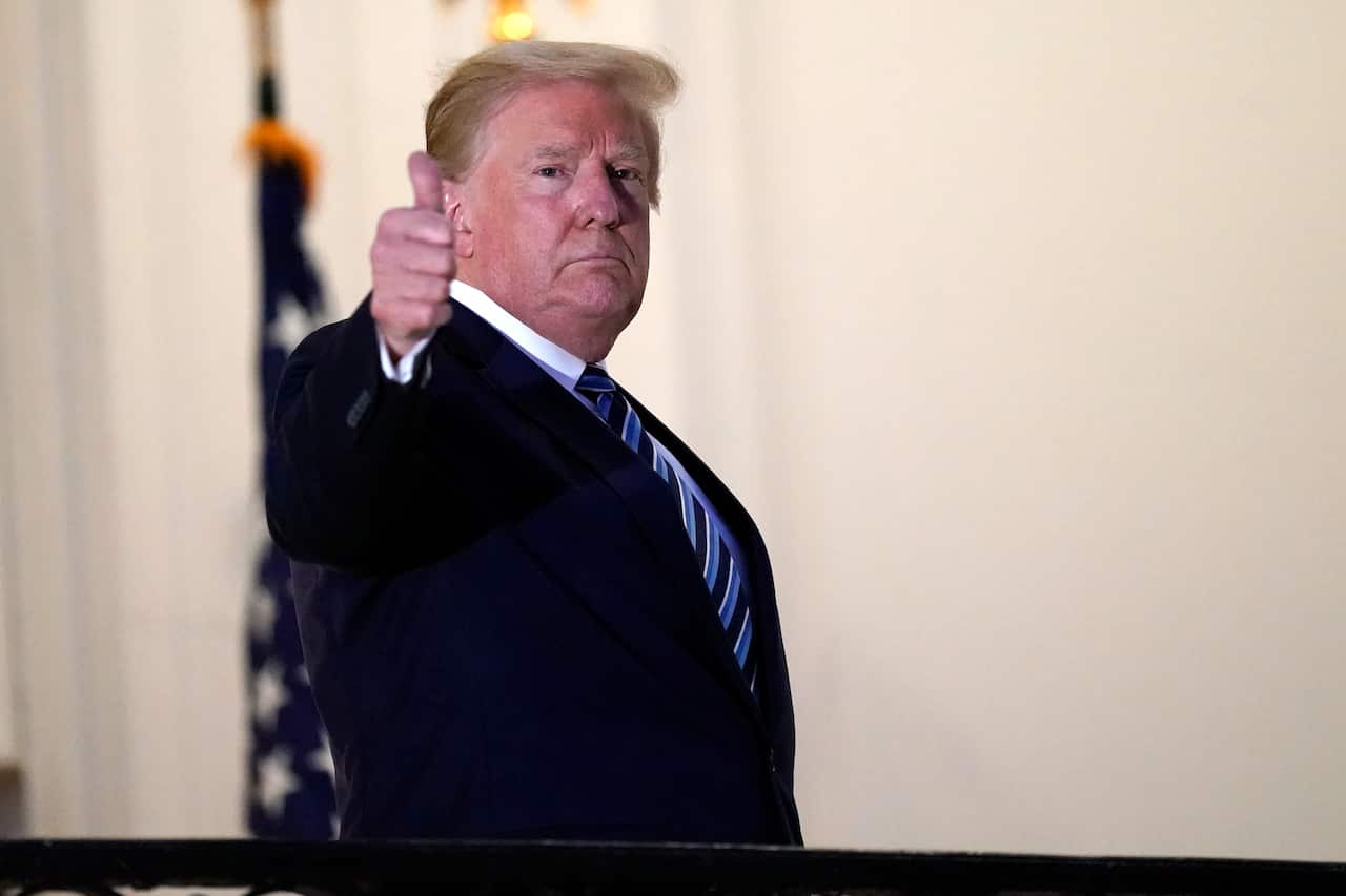 President Donald Trump gestures as he returns to the White House, after leaving Walter Reed National Military Medical Center.