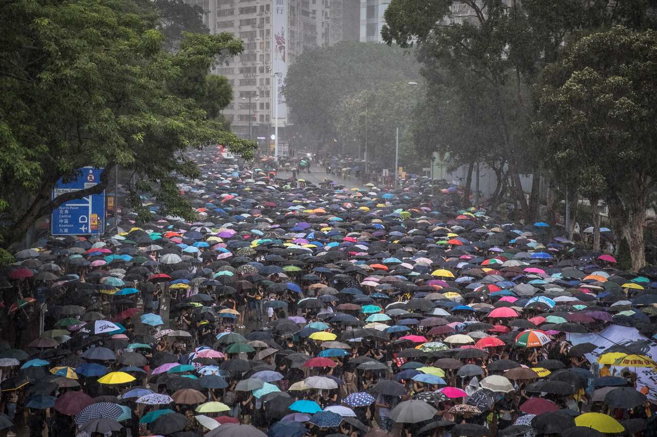 Protesters march while holding umbrellas during the demonstration as more than one million demonstrators take to the streets. 
