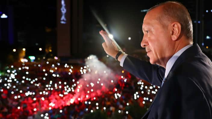 Recep Tayyip Erdogan waves to celebrating supporters