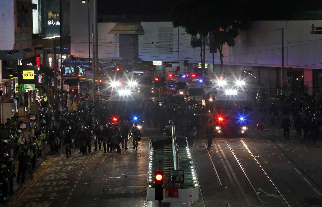 Riot policemen march on a street in Hong Kong.