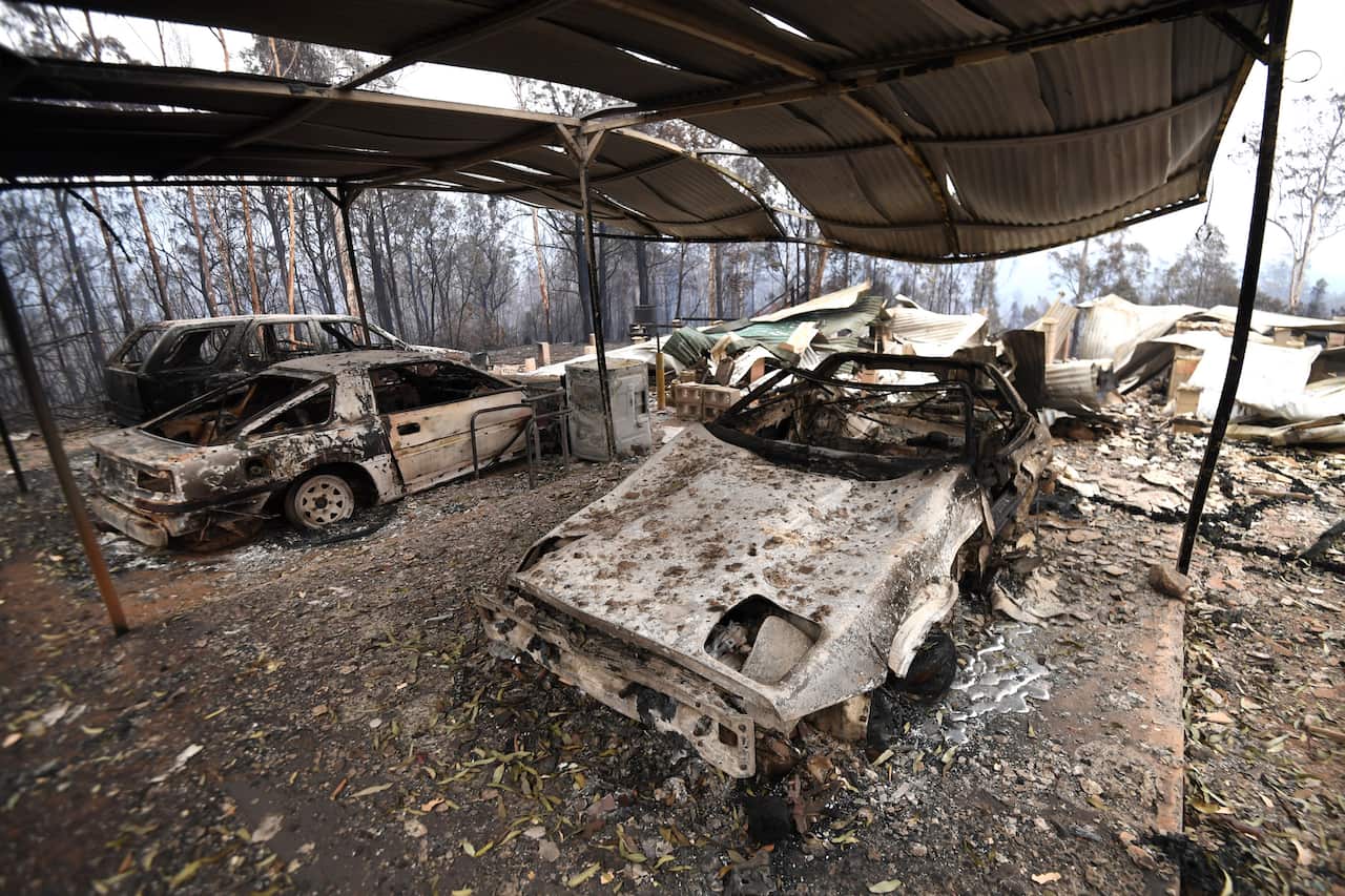 The remains of cars and a house destroyed by bushfire are seen outside of Glenreagh, near Coffs Harbour 