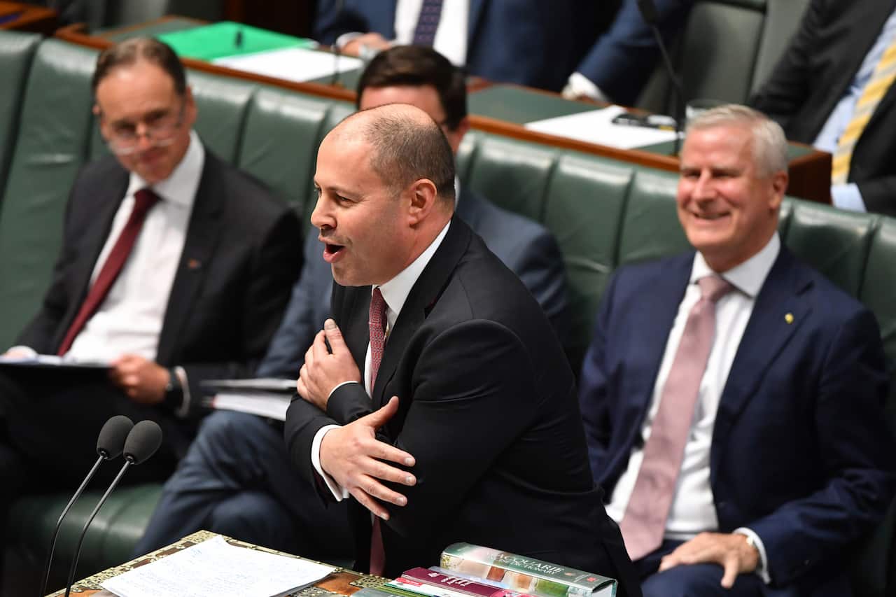 Treasurer Josh Frydenberg hugs himself during Question Time