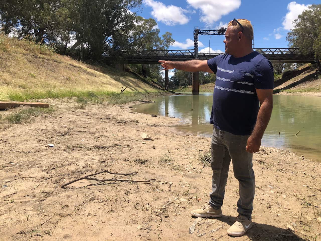 Owen Whyman points to the high water mark on the riverbank.