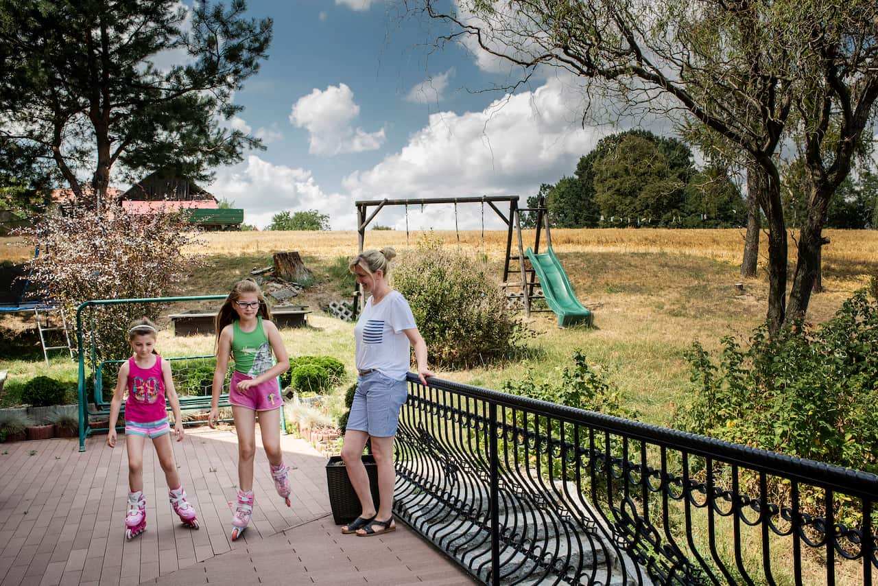 Malwina Kicler, center, and Liliana Kicler, left, of the village of Miejsce Odrzanskie, Poland, Aug. 2, 2019. (Kasia Strek/The New York Times)
