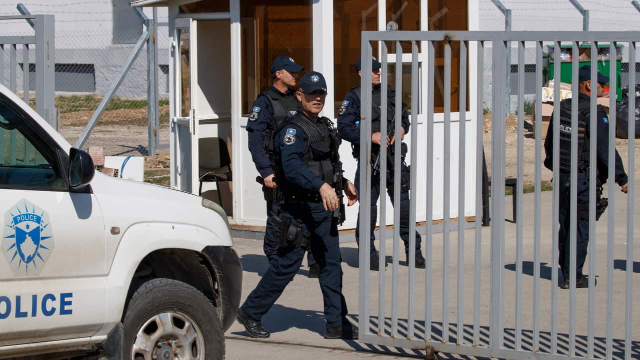 Kosovo police officers secure the compound of the foreign detention center in the village of Vranidoll.