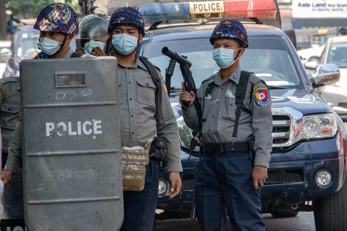 Riot police holds gun as they are about to clash with military supporters and anti coup protesters.