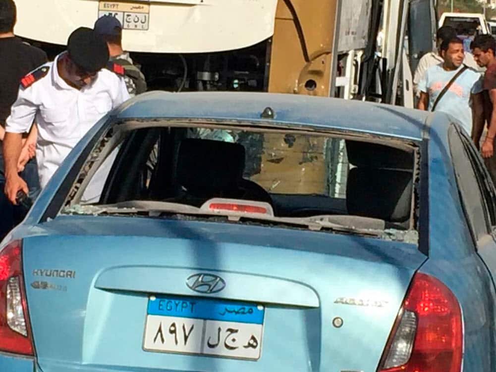 Police inspect a car and a bus that were damaged by a bomb, in Cairo, Egypt, Sunday, March 19, 2019 (AAP)