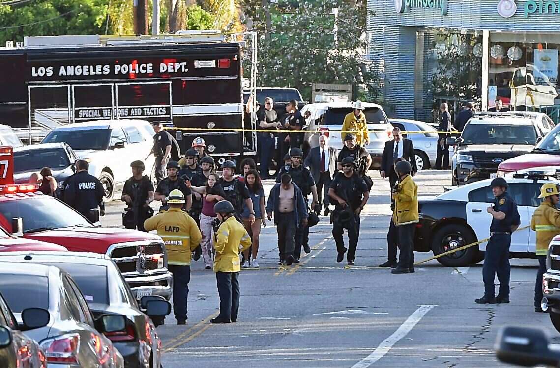 Police officers escort people after the Trader Joe's standoff